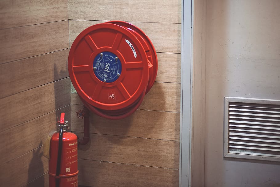 Red Fire Extinguisher Beside Hose Reel Inside the Room, container
