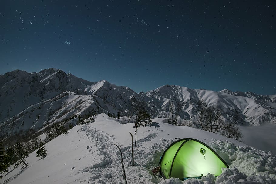 green camping tent on top of snow mountain, night view, mountain climbing