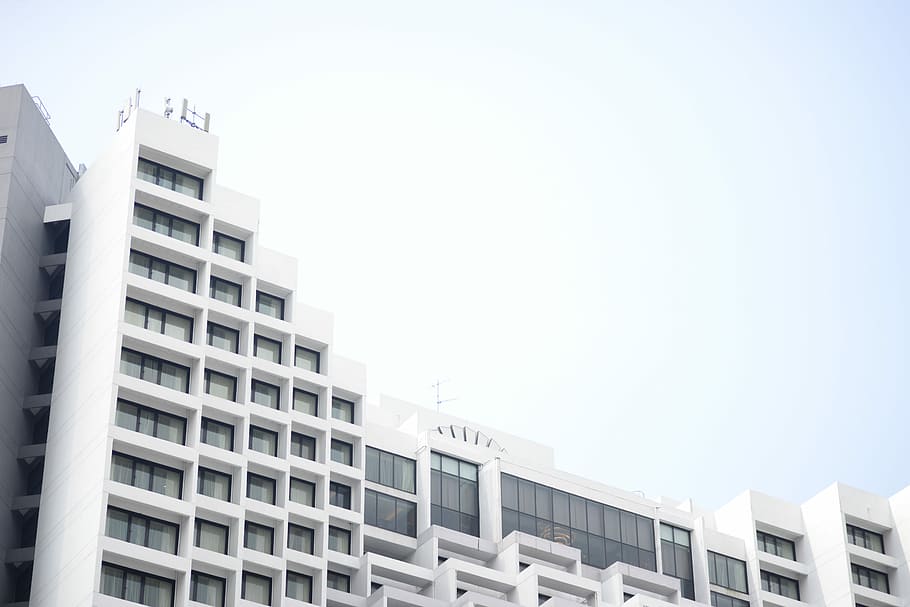 low angle photography of white concrete building, low angle photo of white concrete building under gray sky during daytime HD wallpaper