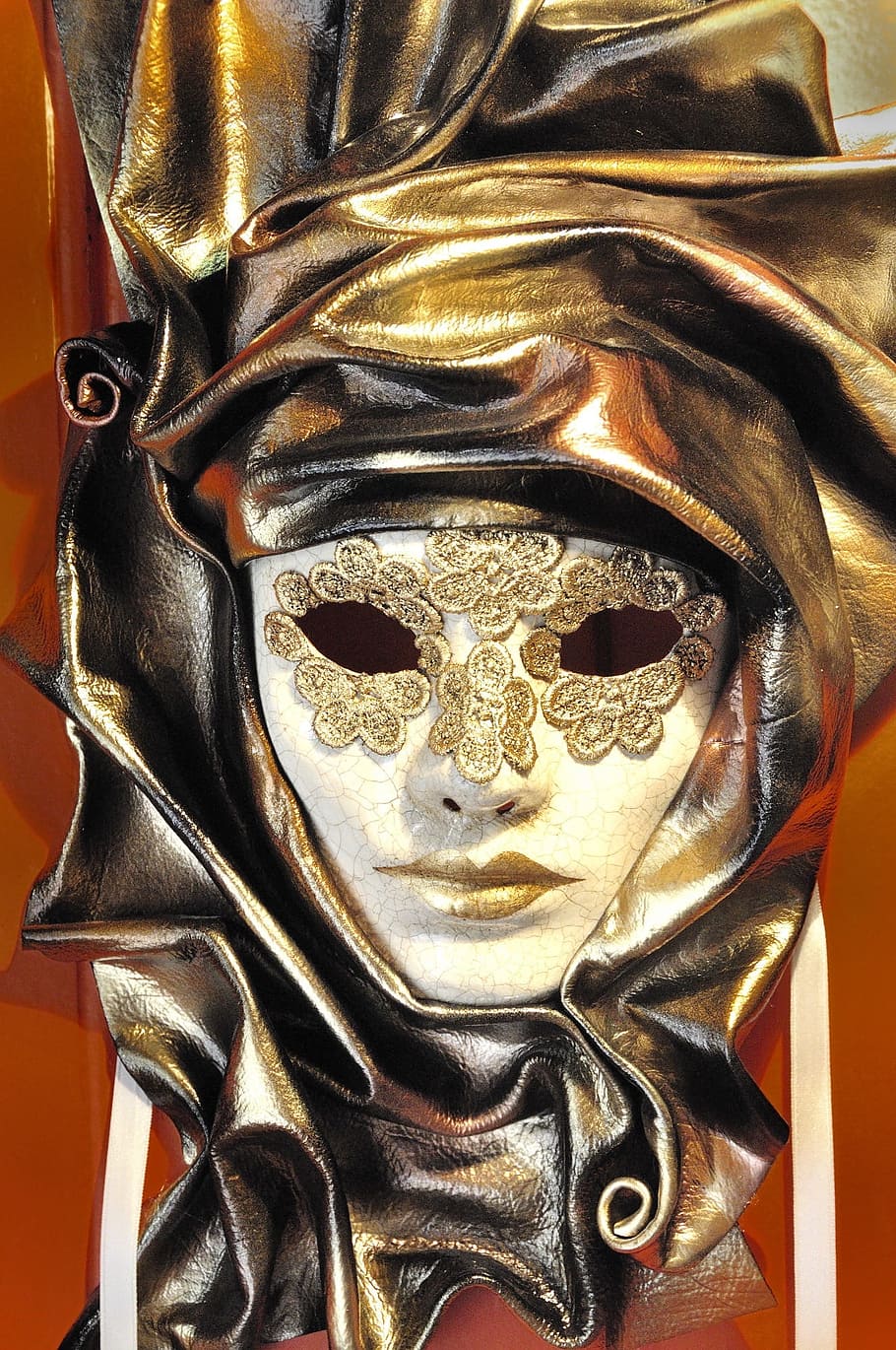 gold leather mask placed on red surface, carnival, venice, italy