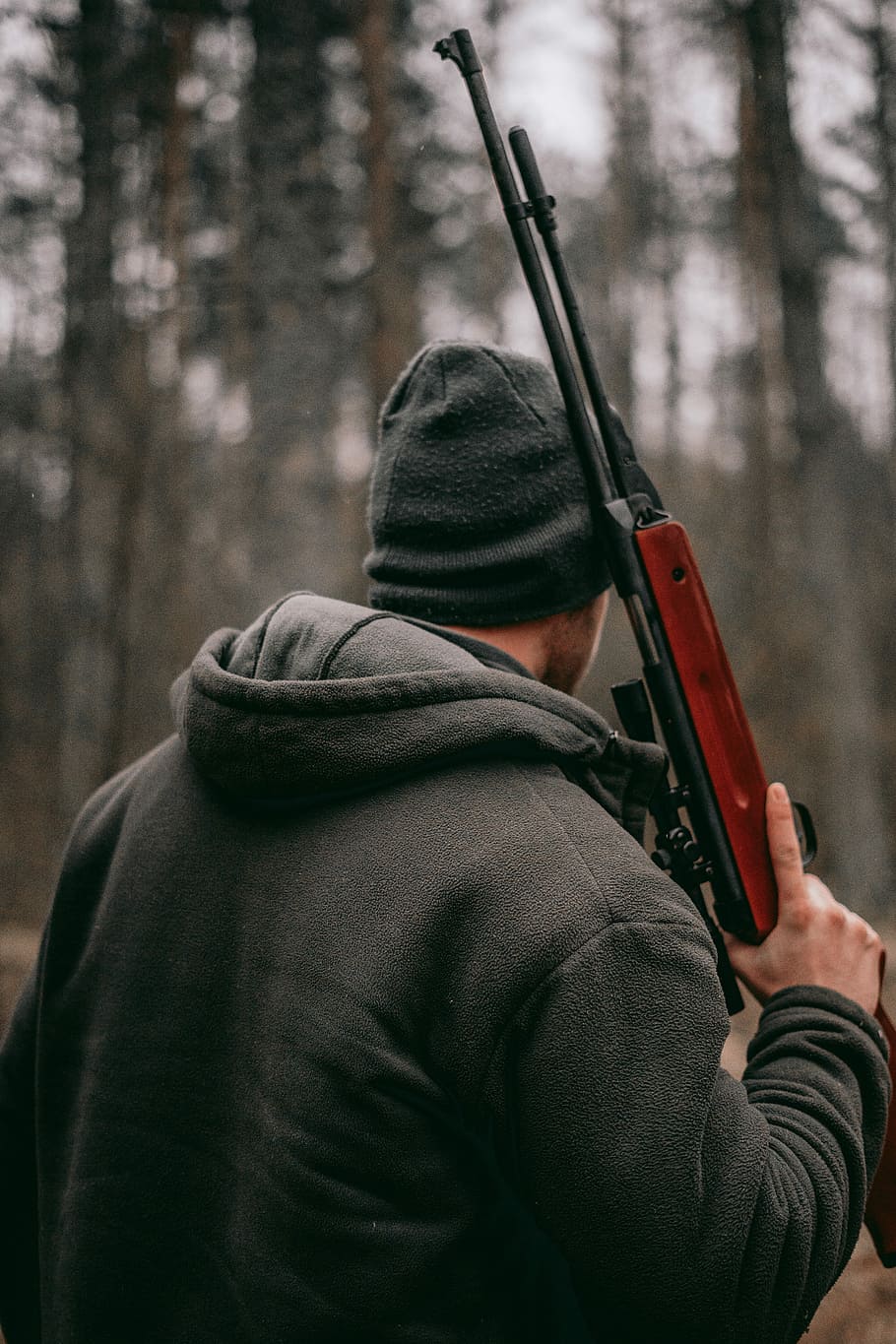 man holding brown and black sniper rifle in shallow focus photography, man holding hunting rifle