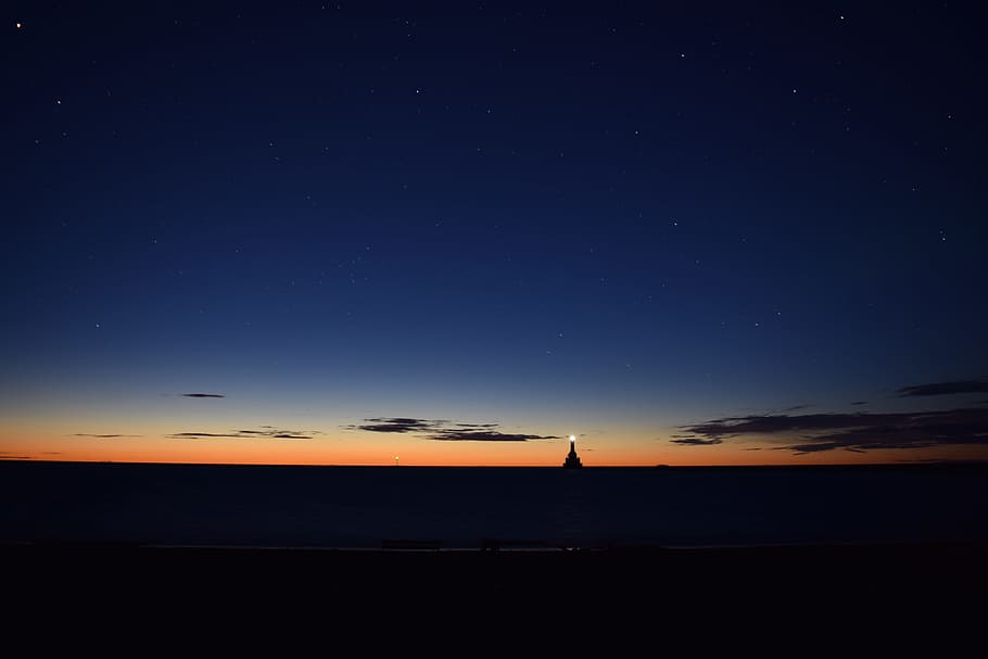 lighthouse on body of water, silhouette photo of pyramid during golden hour HD wallpaper