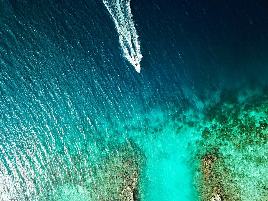 boat moving toward island, aerial photography of a boat near coastal rocks, HD wallpaper