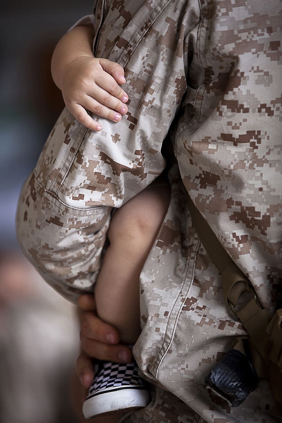close up photograph of man in military jacket holding baby, dad