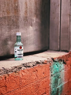 clear glass Bacardi bottle on window, clear glass bottle on gray concrete wall HD wallpaper