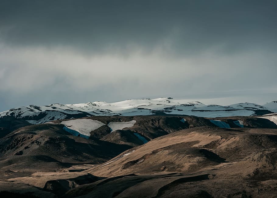 snow capped mountain under dim sky, bird's eye view of brown mountains HD wallpaper
