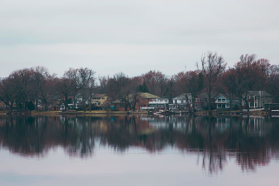white and grey houses near body of water under cloudy sky during daytime HD wallpaper