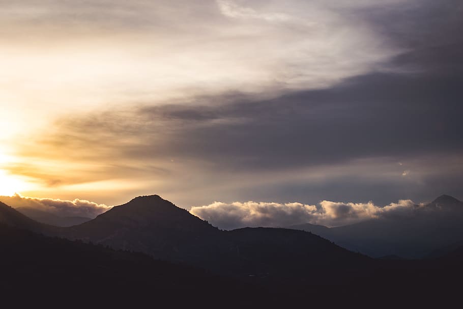 silhouette of mountain under cloudy sky at golden hour\, mountain under cloudy sky HD wallpaper