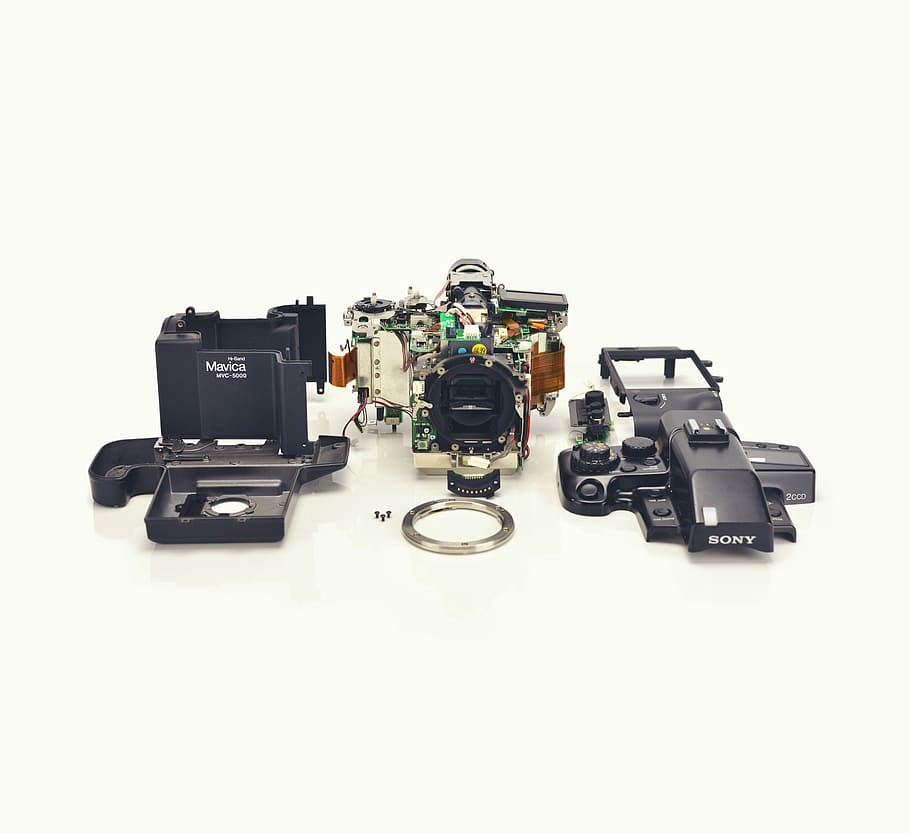 three assorted electronic components, black Sony DSLR camera
