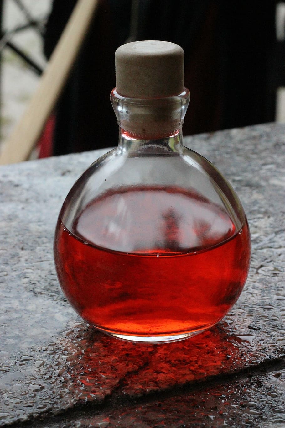 close-up photo of clear glass bottle with red liquid, potion