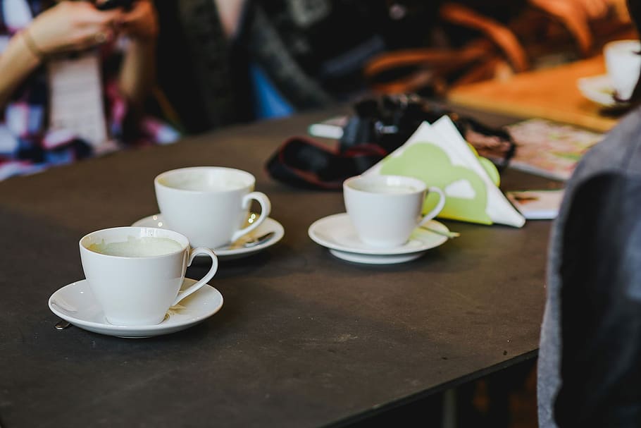 Laptop, a smartphone, magazines and cups of coffee on a table HD wallpaper