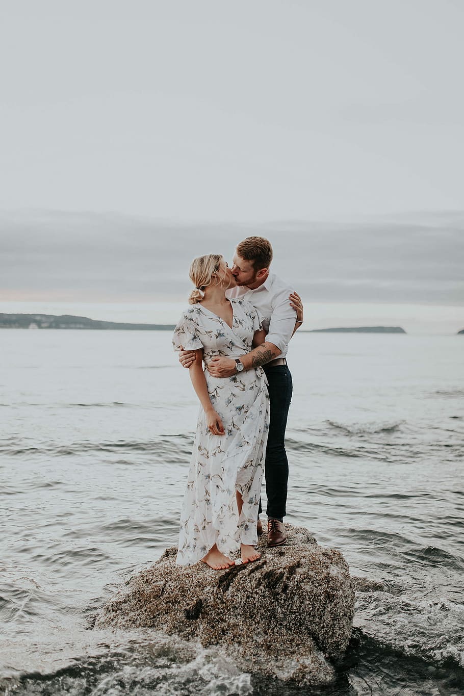 man and woman kissing on top of rock at beach, couple, love, ocean
