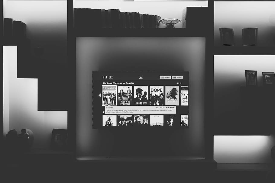 black flat screen TV mounted on shelf, grayscale photography of flat screen smart television turned on
