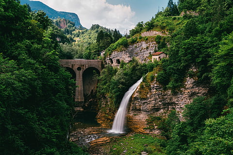 water fountain near concrete bridge and surrounded of trees at daytime, waterfall beside concrete bridge HD wallpaper