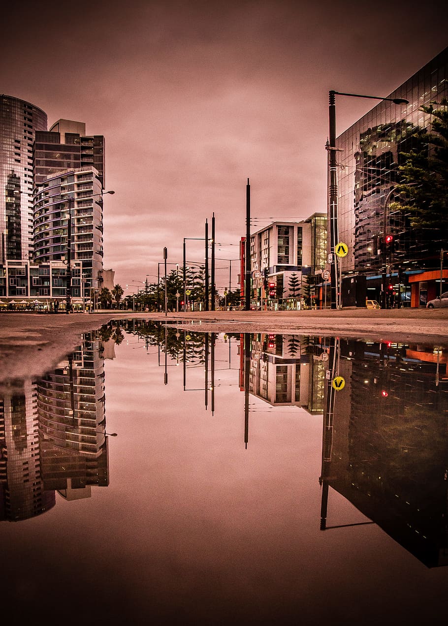 Reflective photography of building with rain flood during day time, grayscale photo of water on road near buildings HD wallpaper