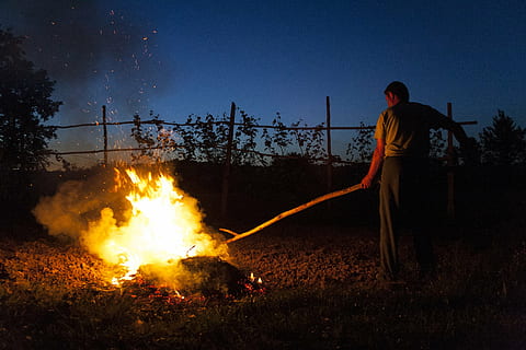 man holding stick burning wood, fire, flame, cleaning, fall cleaning HD wallpaper