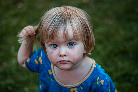 selective focus photography of girl holding her hair, macro photography of toddler in blue floral top HD wallpaper