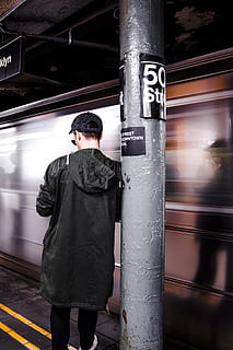 man leaning on the post, man standing beside running train, In motion HD wallpaper