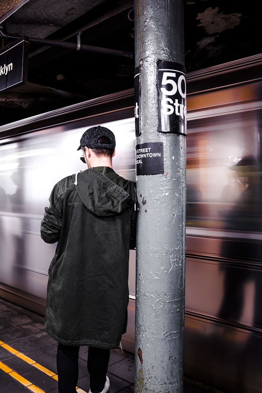 man leaning on the post, man standing beside running train, In motion HD wallpaper