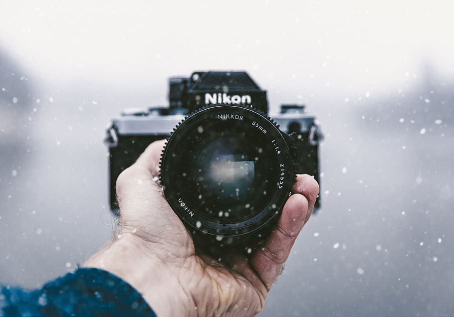 person holding Nikon DSLR camera, person holding black Nikon DSLR camera HD wallpaper