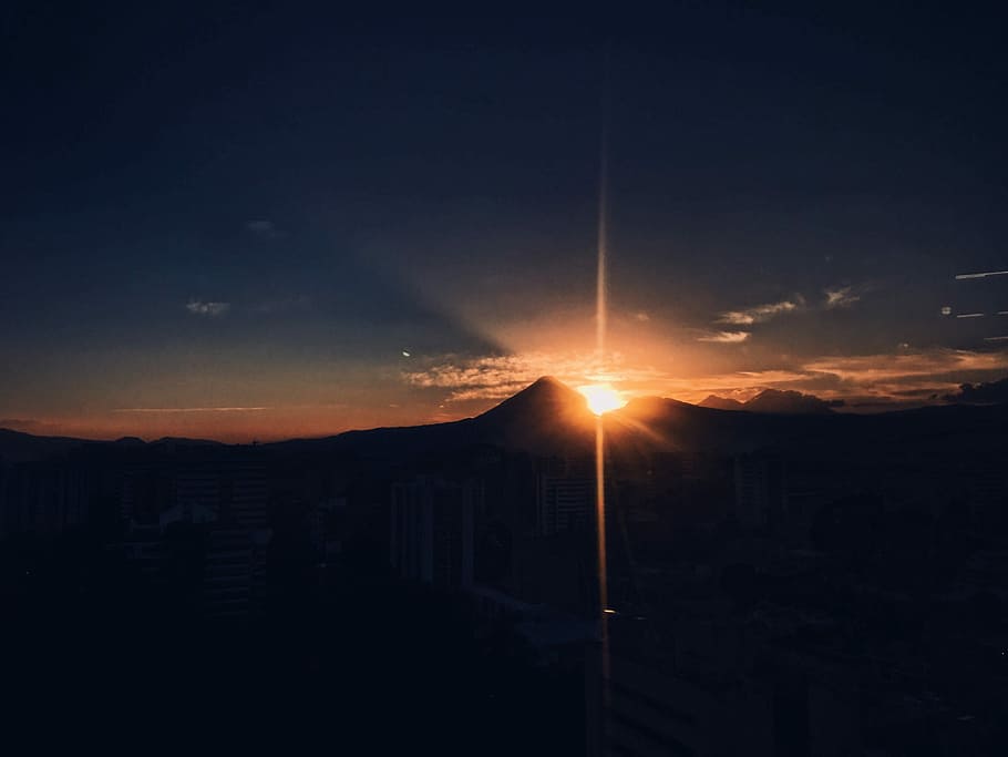 silhouette of houses, sun slightly covered by mountain, sunset HD wallpaper