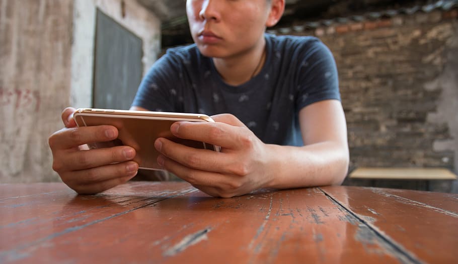 man holding phone, mobile, macro, hand, game, iphone, men, technology HD wallpaper
