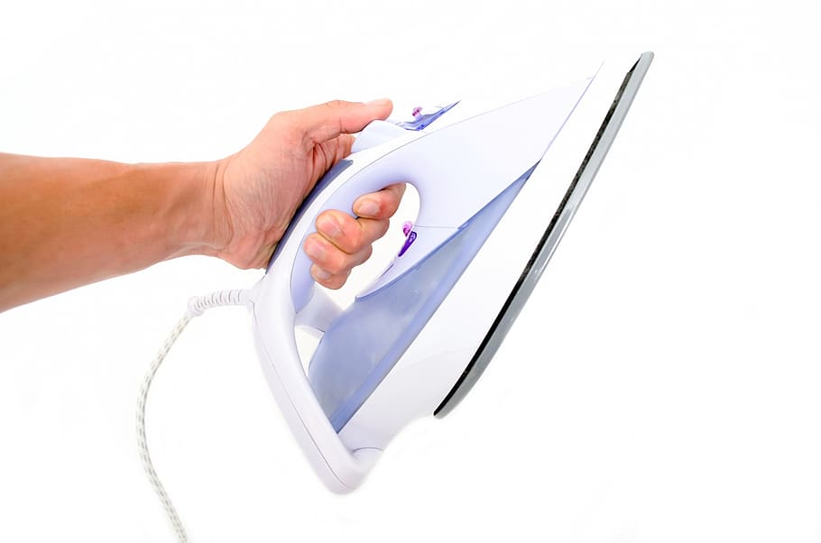 person holding white steam iron, ironing, close-up, isolated