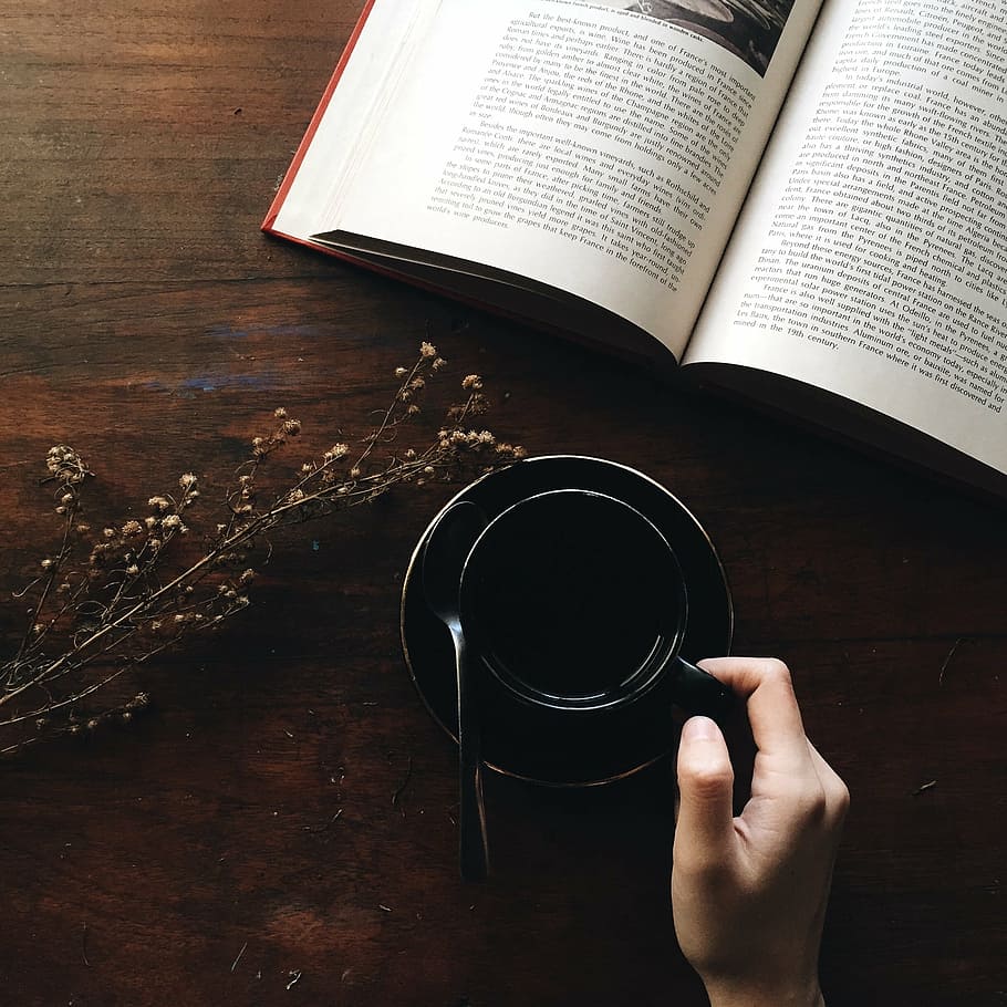 person holding black coffee mug with saucer, book, caffeine HD wallpaper