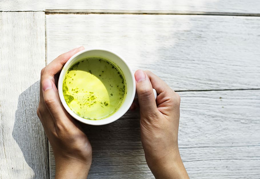 person holding white ceramic mug on white table, beverage, matcha HD wallpaper