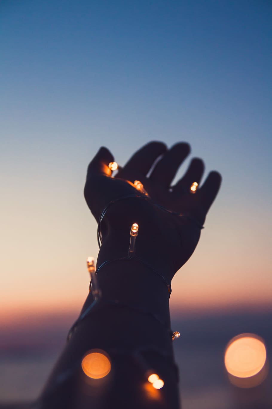person showing left hand with string lights, person with outstretched hands having string lights wrapped around it, HD wallpaper