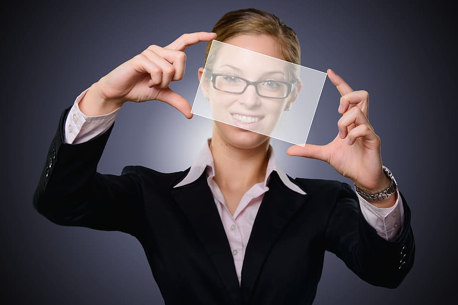 woman wearing black framed eyeglasses and black blazer holding glass panel HD wallpaper