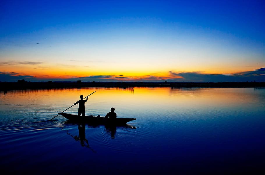 silhouette photography of two people on boat, tam giang lagoon