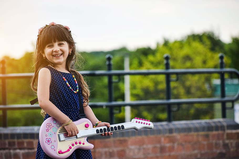 girl playing a white guitar, happy, fun, kids, musician, electric