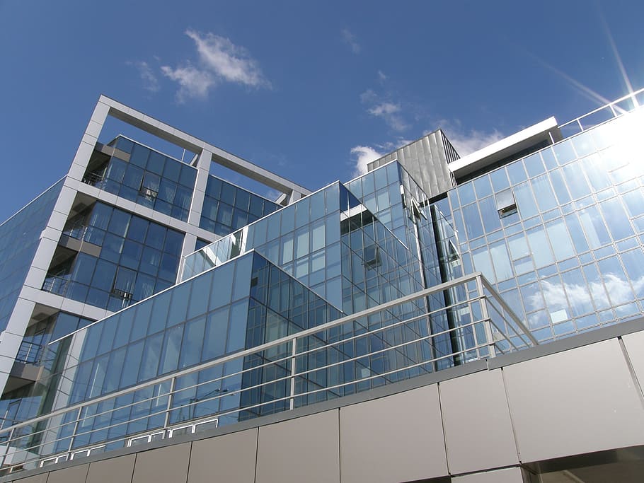 clear glass and gray concrete building in low angle photography HD wallpaper