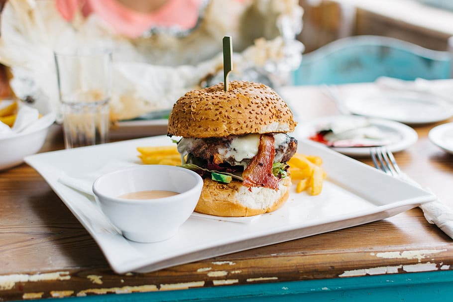 brown burger dish on white ceramic plate, Juicy Burger in a Vibrant Interior, HD wallpaper
