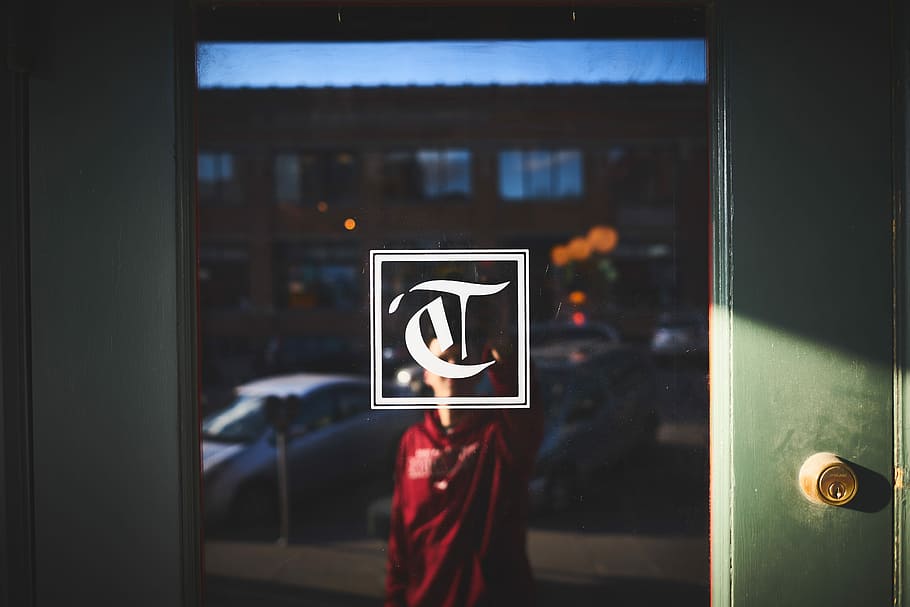 Person in red shirt in reflection of door window with lock and logo, man standing in front of glass door HD wallpaper