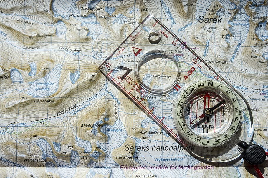 clear and white compass with ruler on map illustration, compass on top of Sarek National map