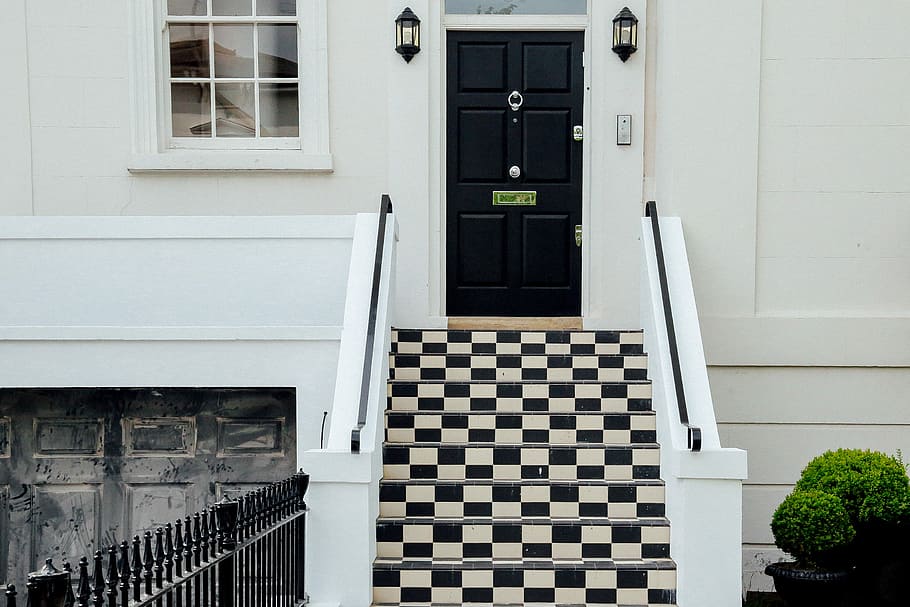 closed white and black house with checked staircase, white and black concrete stairs front of black wooden panel door HD wallpaper