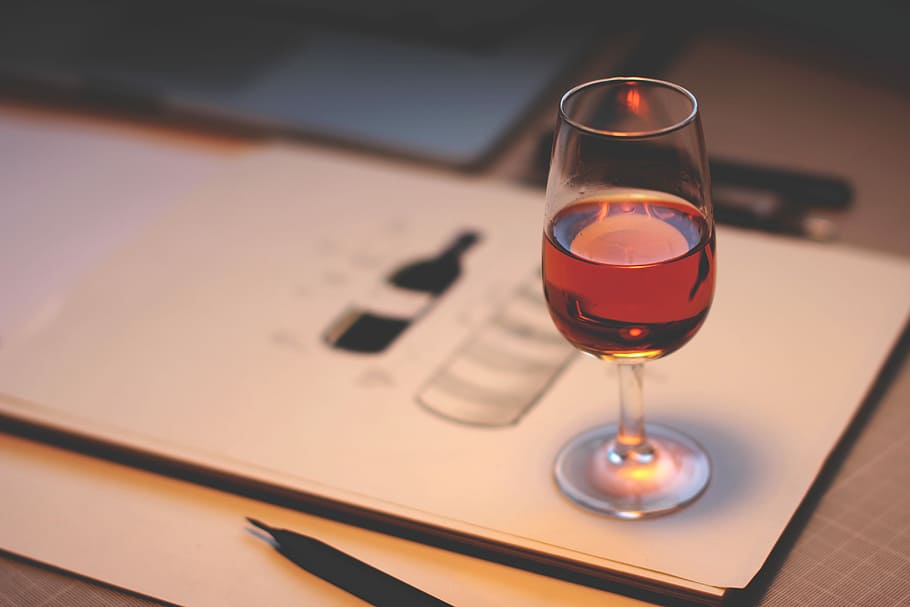 clear wine glass with red liquor, clear short-stemmed glass on white paper HD wallpaper