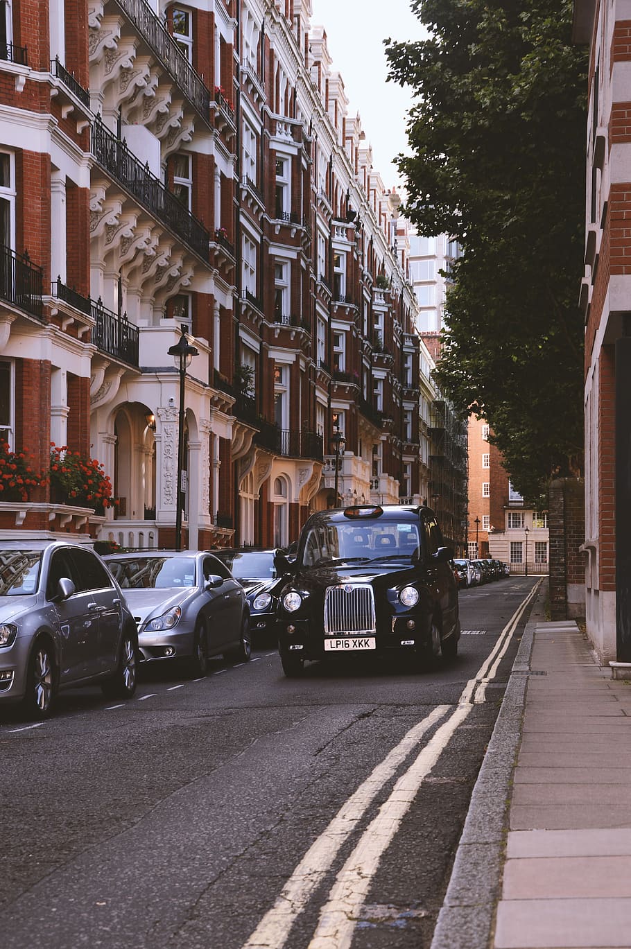 black classic car on grey top road beside high-rise concrete building on daytime HD wallpaper