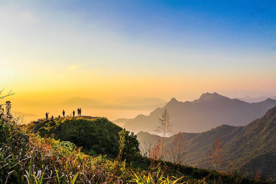 Photo of People Standing on Top of Mountain Near Grasses Facing Mountains during Golden Hours HD wallpaper