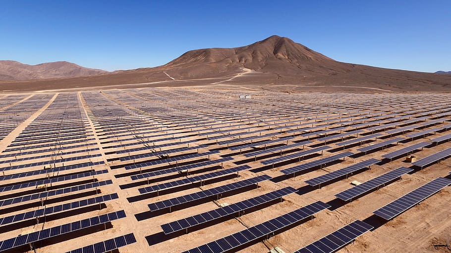 landscape photography of blue solar panels, top view of solar panels in the middle of the dessert