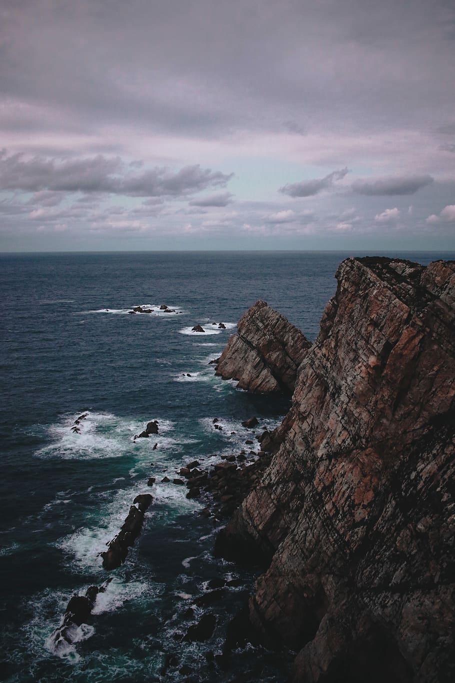 rock formation near the sea during daytime, photography of cliff HD wallpaper