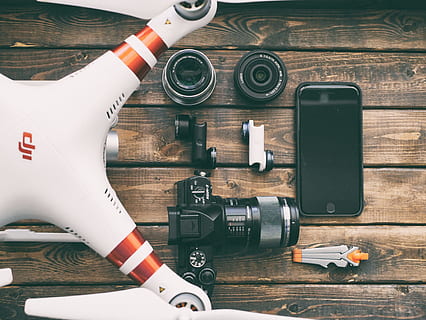 white and red DJI quadcopter drone, white and red DJI phantom beside black DSLR camera HD wallpaper