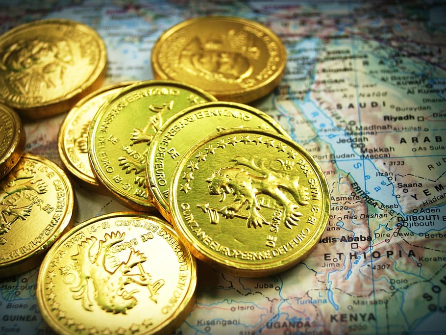 gold-colored coins on top of world map, cash, isolated, tower