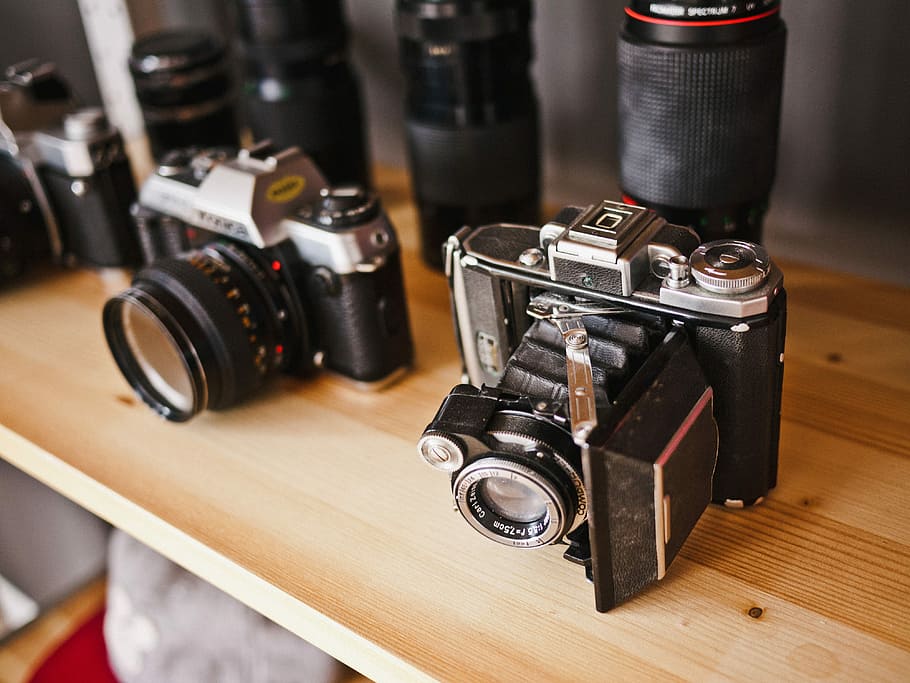 two black-and-gray assorted cameras on the brown wooden table HD wallpaper
