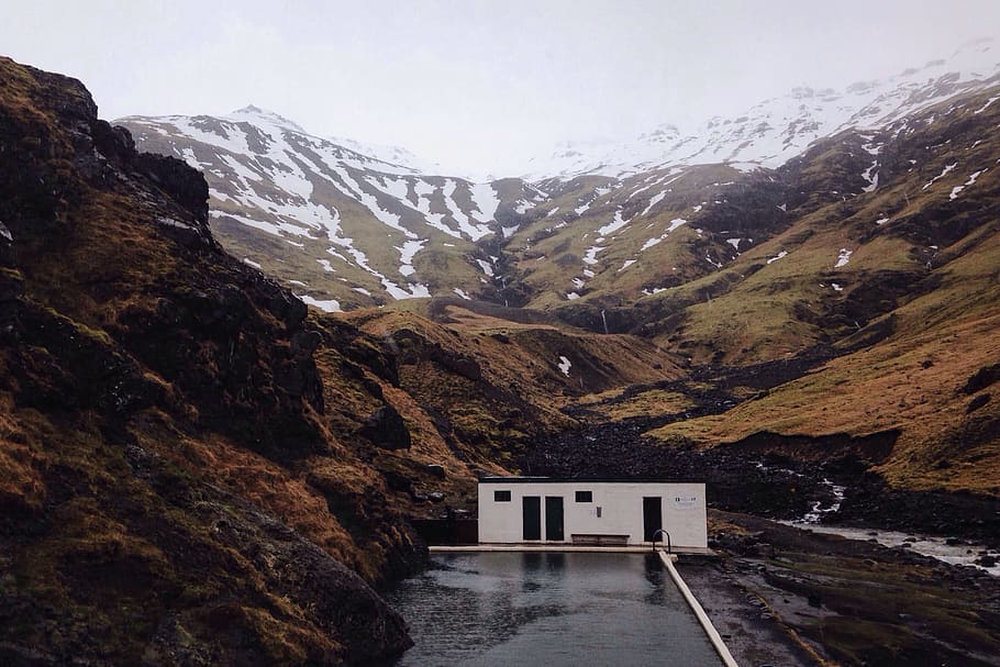 A building sits in the dramatic mountain landscape in Iceland HD wallpaper