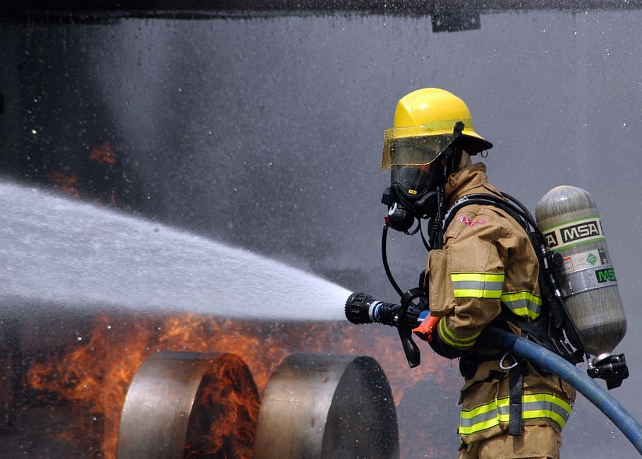 firefighter holding hose, training, simulated plane fire, flames