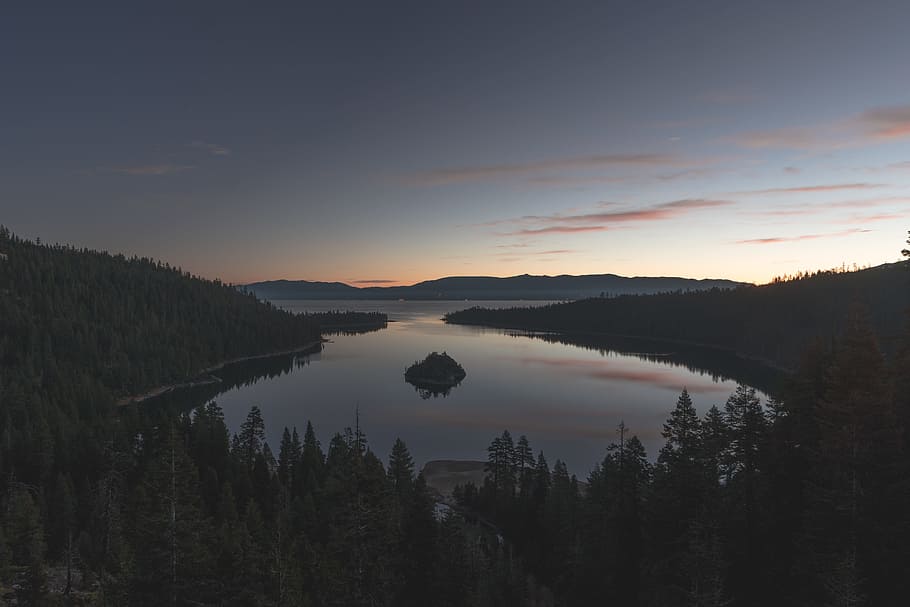 aerial view photography of lake surrounded by pine trees, body of water in the middle of mountains HD wallpaper