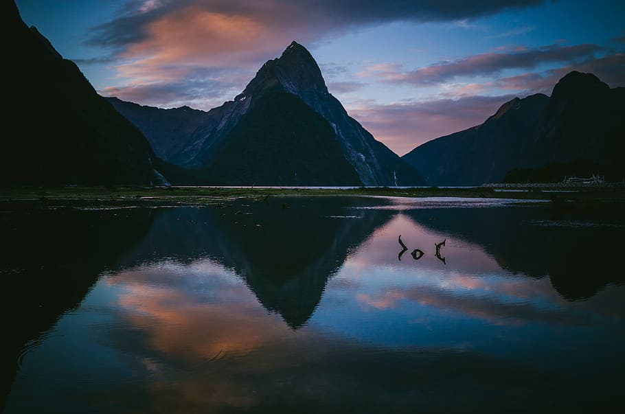 photo of lake with reflection of mountains under cloudy sky, mountain near body of water wallpaper HD wallpaper